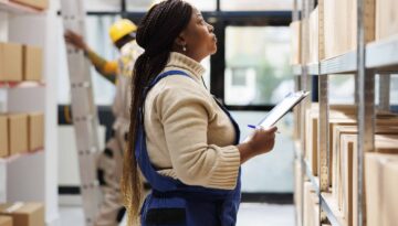 Warehouse supervisor looking at parcels and taking notes