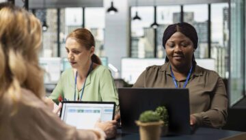 Diverse office colleagues reviewing business insights on laptop