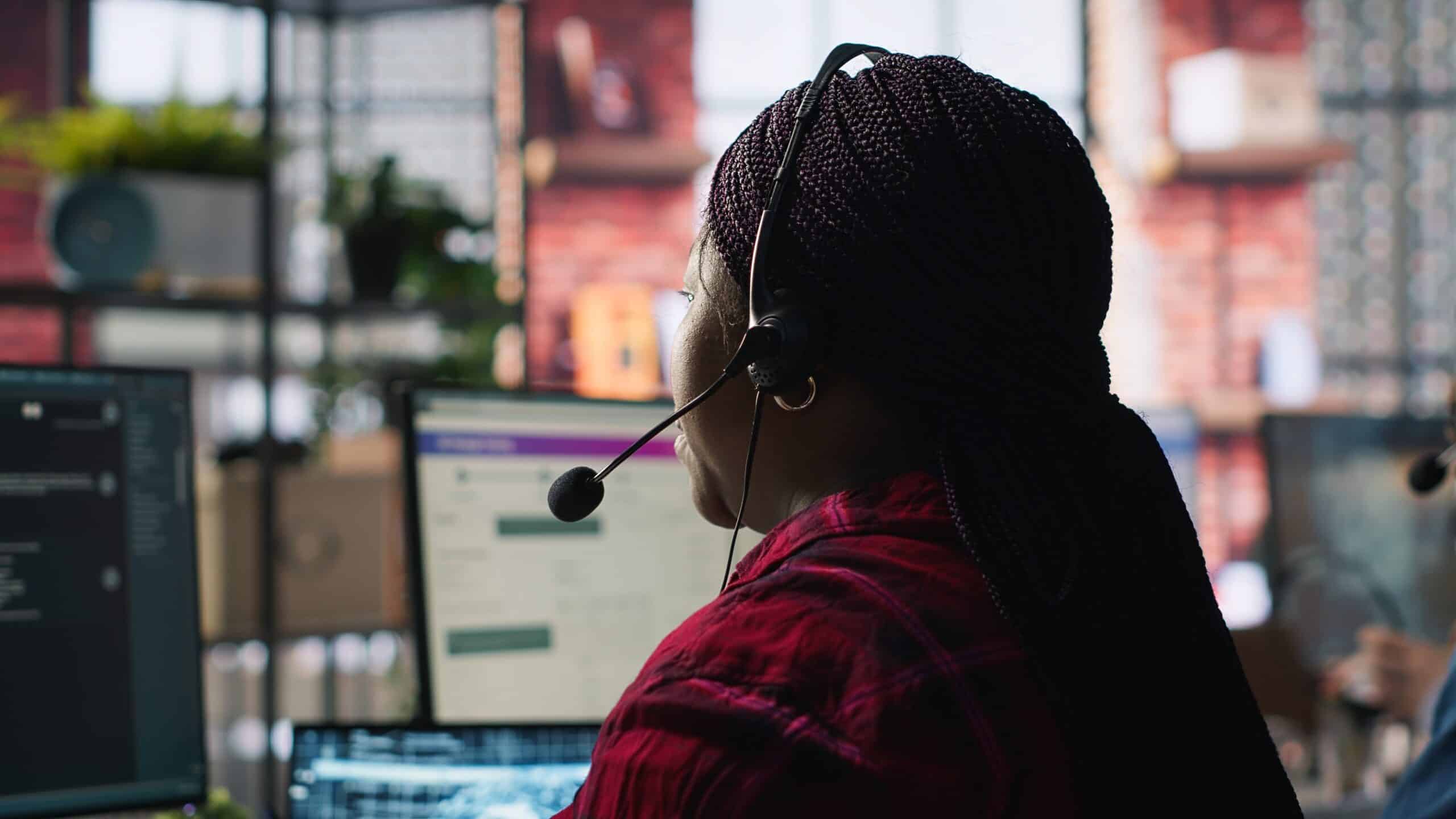 Call center worker in office using AI chatbot to reply to customers